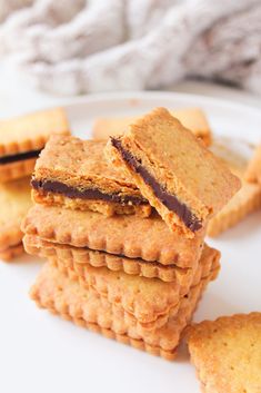 several cookies stacked on top of each other on a white plate next to a blanket