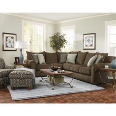 a living room filled with furniture and a large rug on top of a hard wood floor