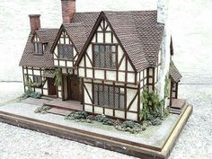 a model house is shown on display in front of a white building with brown trim