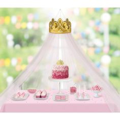 a pink cake and cupcakes are on a table with a canopy over it