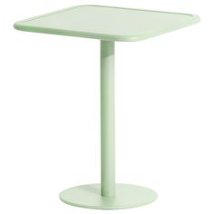 a small table with a white top and green base on a white background, it is also used as a side table for seating