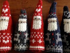 four knitted santas are lined up on a table