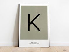 a black and white poster with the letter k in it's center on a wooden floor