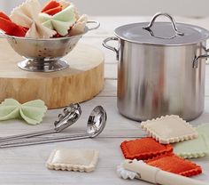 a pot with some kind of food in it next to utensils and spoons