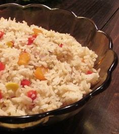 a bowl filled with rice and vegetables on top of a wooden table