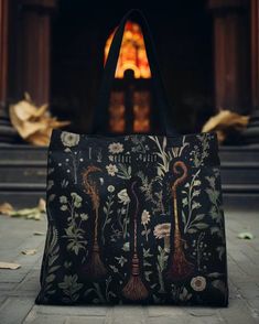 a black bag sitting on top of a floor next to a stair case with flowers and vases painted on it