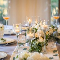 the table is set with white flowers and candles