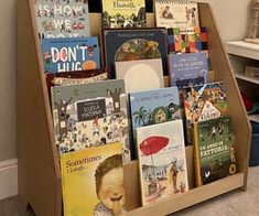 a bookshelf filled with children's books on the floor