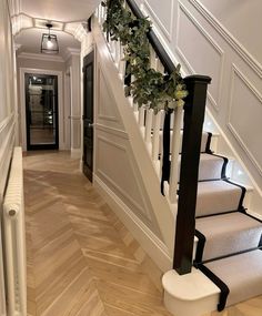 the stairs are decorated with wreaths and greenery on each handrail, along with carpeted flooring