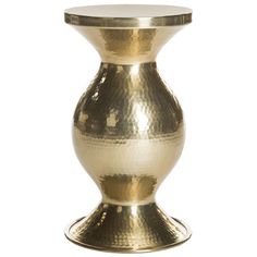 a gold vase sitting on top of a white table