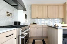 a kitchen with white marble counter tops and wooden cabinetry, along with an area rug on the floor