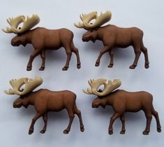 four moose figurines are shown on a white surface