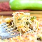 a close up of a fork with food on it and cucumbers in the background