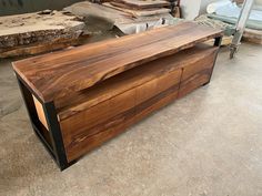 a large wooden box sitting on top of a floor next to other wood pieces in a room