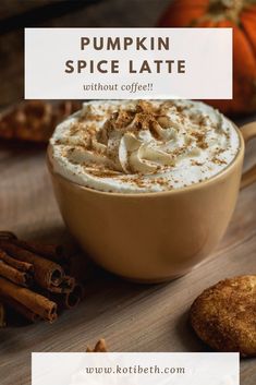 pumpkin spice latte with whipped cream in a mug and cinnamon sticks on the side