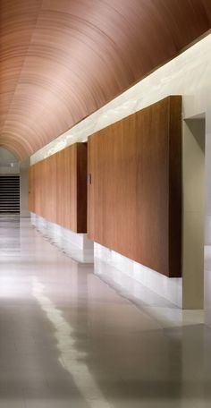 an empty hallway with wood paneling and white floors