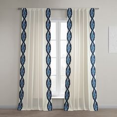 a white curtain with blue trim hanging in front of a window