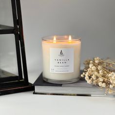 a candle sitting on top of a table next to a book and some dried flowers