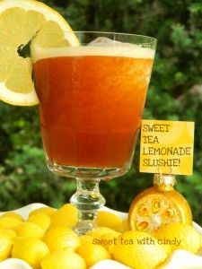 a glass filled with lemonade next to sliced lemons and a sign that says sweet tea lemonade slushie