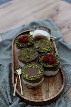 small desserts are arranged on a wooden tray