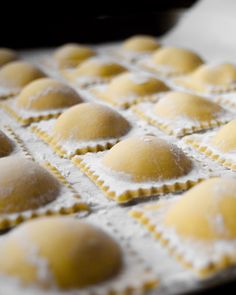 some ravioli sitting on top of a pan covered in powdered sugar