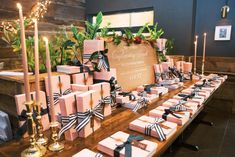 the table is set up with pink and black gift boxes