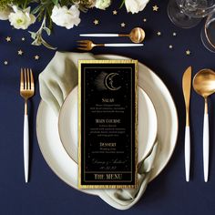 a table setting with silverware, gold and black place settings and napkins on it