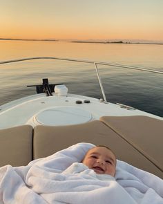 a baby wrapped up in a blanket on a boat