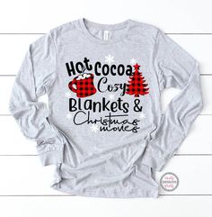 "Welcome to Maddy Paddy Designs Etsy Shop! This listing is for a Hot cocoa cozy blankets & Christmas movies shirt. This is a UNISEX Jersey Long Sleeve Tee. * If you would like to see the design on a different style shirt please message me. Solid colors * 100% cotton Athletic Heather * 90% cotton * 10 % polyester Deep Heather * 52% cotton * 48% polyester I suggest that you measure your shirt that you already own to compare sizing with the size chart in the photos. Please note that ALL SALES A Christmas Cotton T-shirt For Loungewear, Cozy Long Sleeve Christmas Tops, Cozy Cotton Christmas Tops, Cozy Winter T-shirt For Loungewear, Cozy Christmas Tops With Graphic Print, Cozy Christmas Graphic Print Tops, Christmas Family Outfits, Biggie Smalls Shirt, Ladies Christmas Shirts