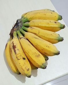 a bunch of bananas sitting on top of a white counter next to a banana peel