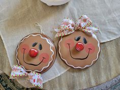 two gingerbread cookies decorated to look like clowns with bows on their heads and noses