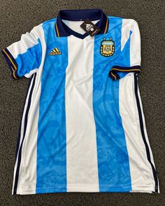 a blue and white soccer jersey laying on the ground