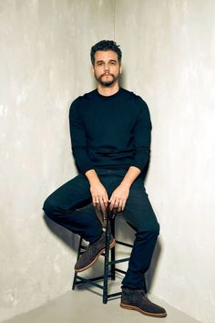 a man sitting on top of a wooden chair