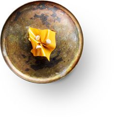 a metal bowl with a yellow bow on the top and two white dots in the middle