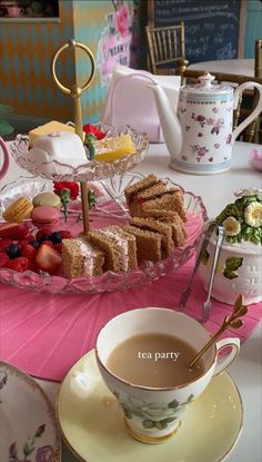 a tea party with sandwiches and fruit on a plate next to a cup of coffee