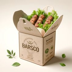 a cardboard box filled with lettuce and sausages on top of green leaves