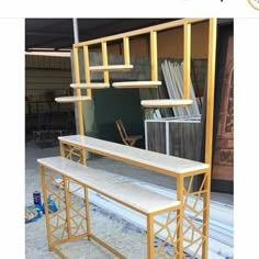 a white bench sitting in front of a window next to a metal rack with books on it