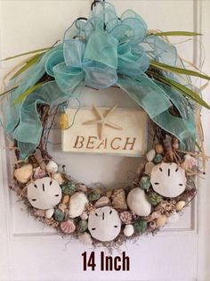 a wreath with shells and starfish is hanging on the front door to welcome guests