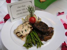 a white plate topped with meat and veggies next to a sign on a table