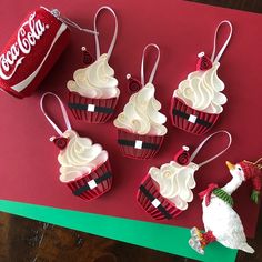 six cupcakes with white frosting on them and a can of coca - cola in the background