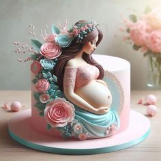 a pregnant woman is sitting on top of a pink and blue cake with flowers around it