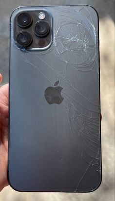 someone holding up their iphone with the cracked screen