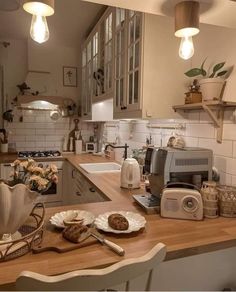 a kitchen filled with lots of counter top space and lights hanging above the stovetop