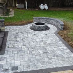 a brick patio with a fire pit in the middle