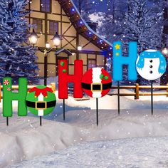 the word holiday spelled out in front of a snow covered house with christmas decorations on it