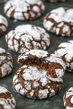 chocolate crinkle cookies with powdered sugar are on a baking sheet, ready to be eaten