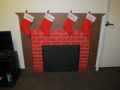 a decorated fireplace with stockings hanging from the mantle