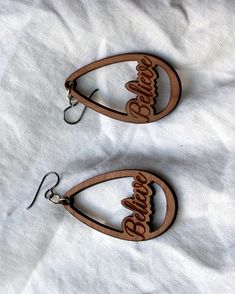 "Beautiful BELIEVE earring set with high quality niobium (anti-allergenic) ear wires. The drop earrings feature the word believe spelled out in cursive. They are cut from 1/8 inch thick renewable cherry wood. The earrings are incredibly lightweight. They hang approximately 2.75\" down and are 1.25\" wide and will last many repeated wearing." Brown Teardrop Hoop Earrings As Gift, Brown Teardrop Hoop Earrings For Gifting, Brown Teardrop Hoop Earrings For Gift, Minimal Rustic, Earthy Jewelry, In Cursive, Earrings Teardrop, Wooden Christmas, Wood Earrings