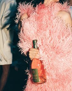 a woman in a pink dress holding a bottle