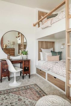 a bedroom with bunk beds and a desk in the corner next to a mirror on the wall